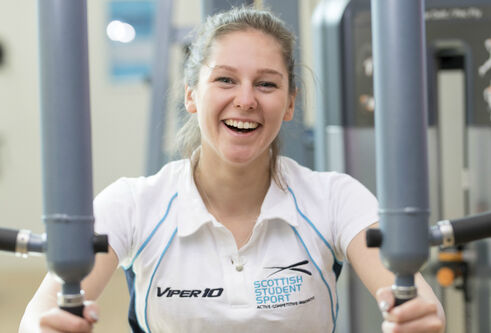 Woman in exercise clothes using a weights machine