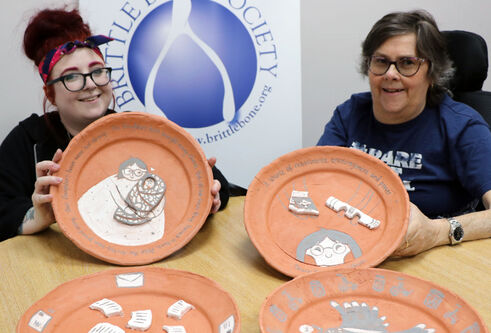 Nicole McLaughlin holding the plates she designed