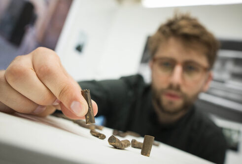 Nick Brodie with his bronze casts of cigarette butts
