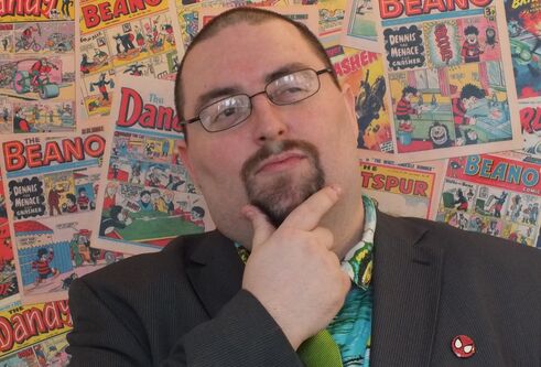 Chris Murray in front of a wall of comics
