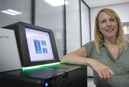 Dr Charis Marwick stands next to machine
