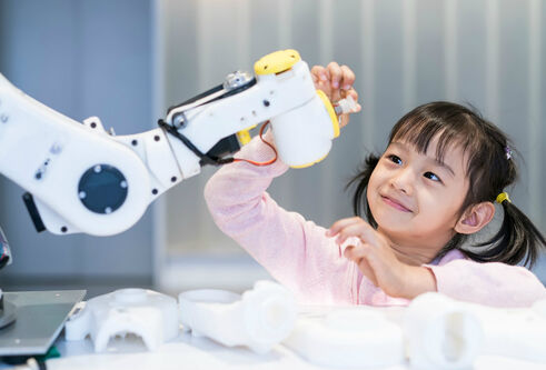 Girl interacting with robotic arm
