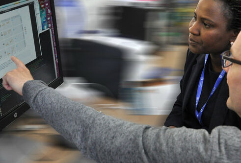 Researchers analysing data and graphs on screen