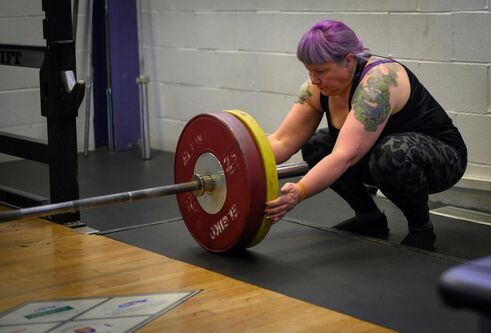 Irene Hallyburton puts weights on a bar