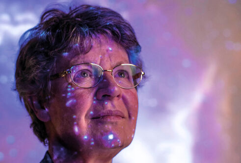 Professor Dame Jocelyn Bell Burnell with image of a galaxy