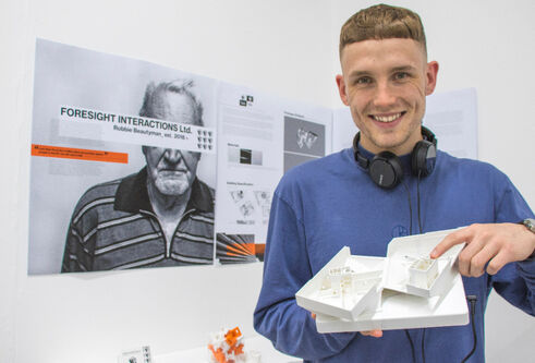 Robbie Beautymean holding his work