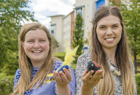 Sara Nevay and Lucy Robertson holding up textiles