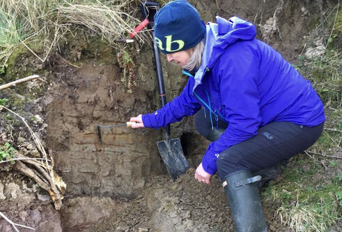 Sue Dawson looking at mud