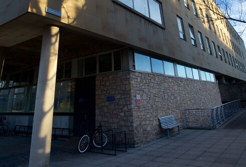 a building entrance with a ramp. There is also a bike and a bench