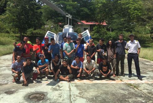 a group of people smiling in front of a helictopter