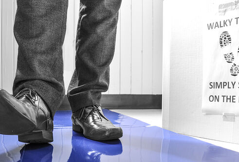 feet walking on a blue sticky mat