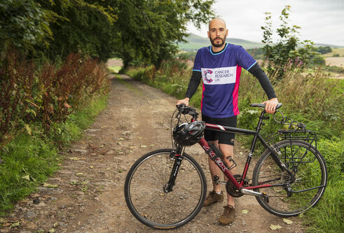 Dr de la Vega standing by bike