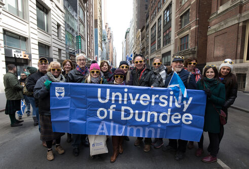 A group of people holding a University of Dundee banner
