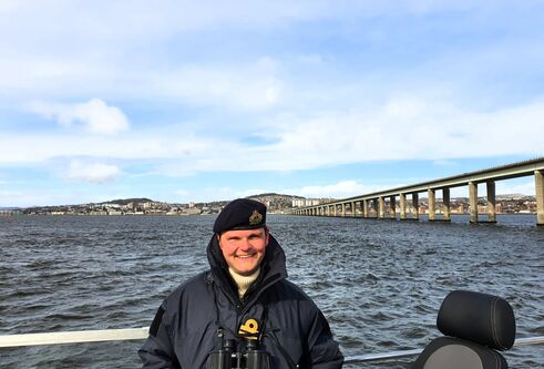 a photo of andy standing in front of a bridge
