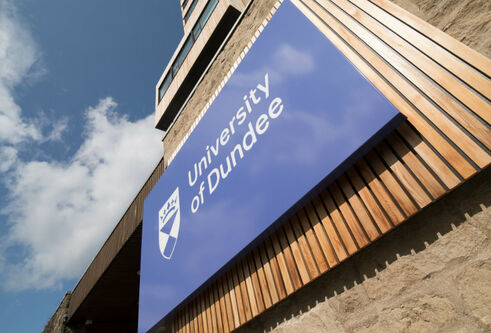 UoD sign with blue sky and clouds