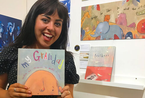 Molly holding the book she illustrated called My Grandad
