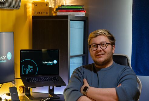 Callum sitting in his office at a desk with a computer on it