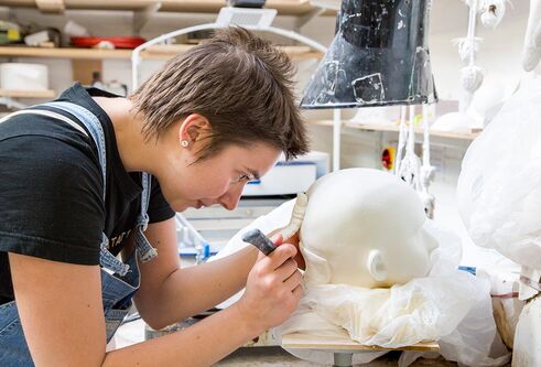 a student working in a ceramic head
