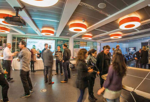 students in an exhibition hall with decorative lights on the ceiling