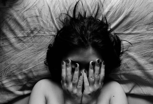 women laying on pillow covering face 