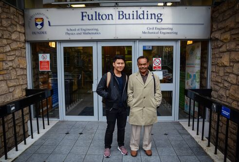 Hakim and Dato standing in front of the Fulton Building's main doors