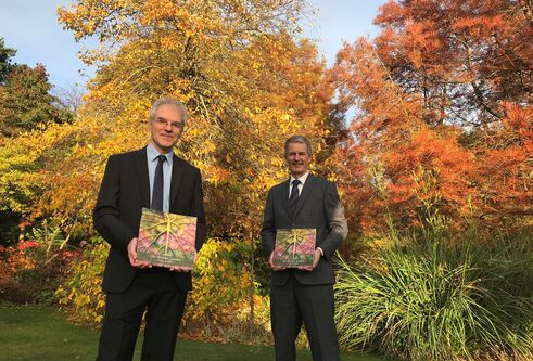 Dr Mark McGilchrist, Chair, Friends of the University Botanic Garden, and Principal Professor David Maguire holding the anthology