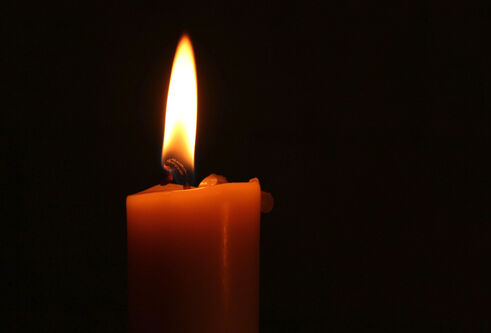 Red candle in front of black background