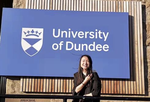 Jing Chen standing in front of the University of Dundee sign
