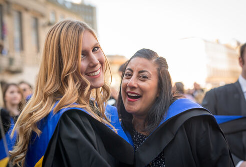 two girls with blue hoods after graduating