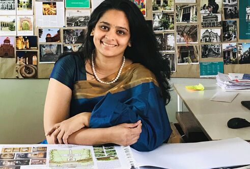 Aishwarya Tipnis with a wall of photos behind her