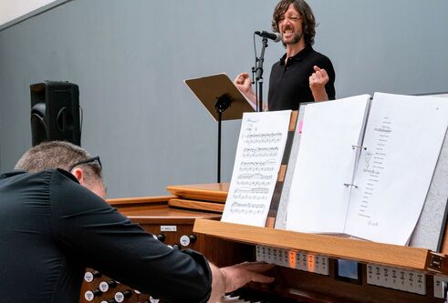 man at organ with man at microphone
