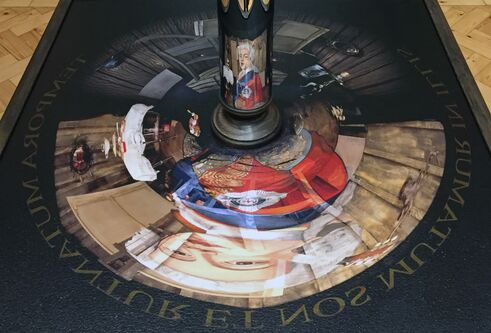 Mirrored tube on painting, which shows a face in the mirror if seen at a certain angle