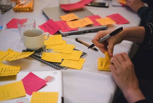 a table with someone writing post-its