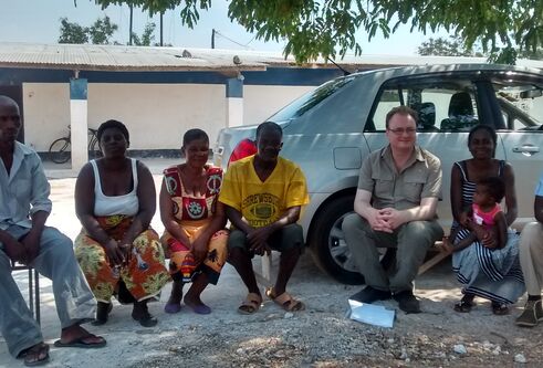 a group of people sit in front of a car