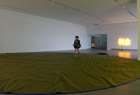 woman alone in gallery with circular fabric on floor