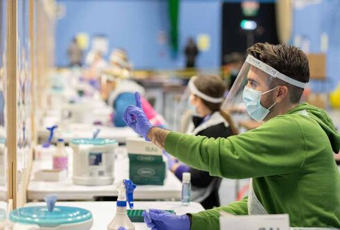 a lab with a person in a face mask working 