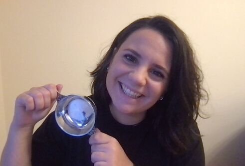 anna holding medal posing in front of plain wall