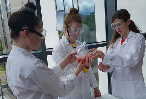women in lab coats with test tubes