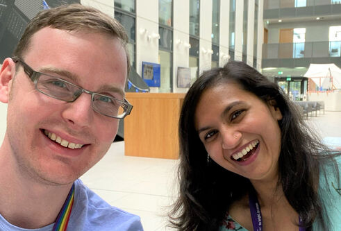 male and female scientist smiling together inside a reception area