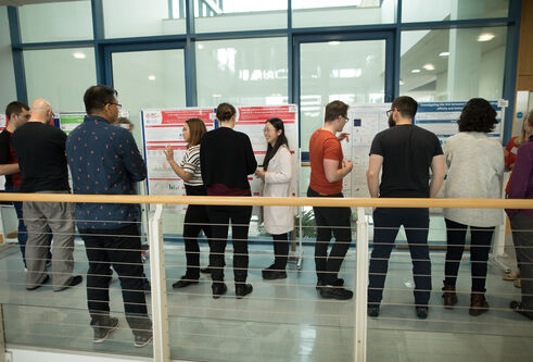 group of people looking at a poster on a glass wall