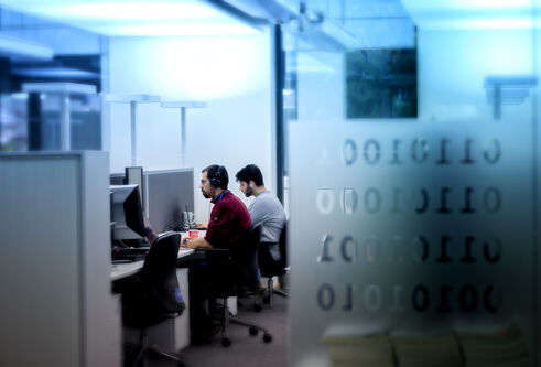People sitting at desks in front of computers