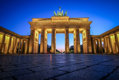 The Brandenburg Gate lit up at sunset, taken from just above the pavement