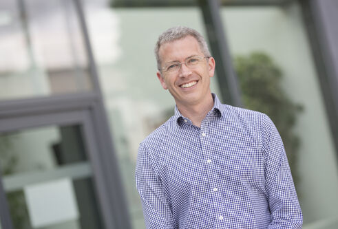 Prof Ewan Pearson smiling in angled outdoors shot