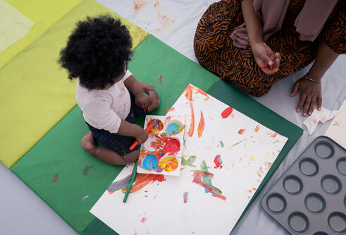 Baby and adult making art together