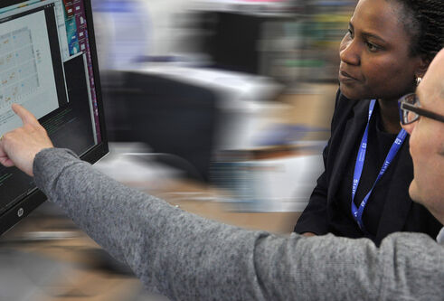 Two researchers looking at a computer screen