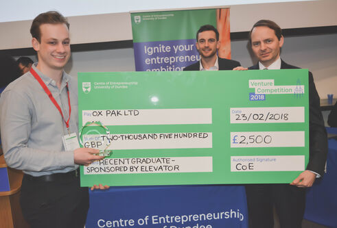 A student receives a novelty cheque for winning Venture Competition 2018