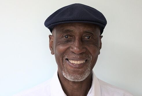 Keith Harris in a black cap and white shirt against white background