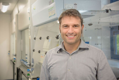 Alessio Ciulli standing in a lab with machines behind him