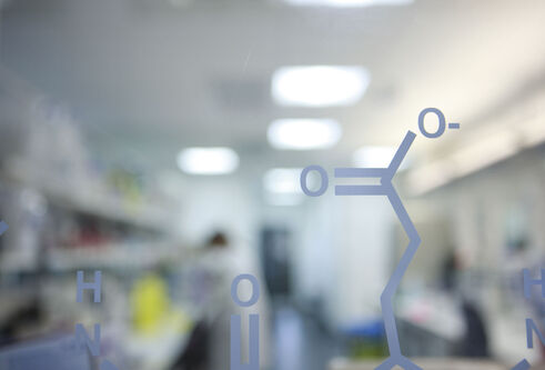 molecule painted on glass wall in front of a blurred out lab