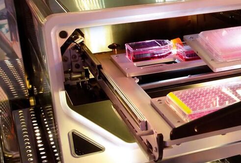 The inside of an instrument that analysis live cells showing trays of microplates